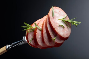 Sliced sausage with rosemary.