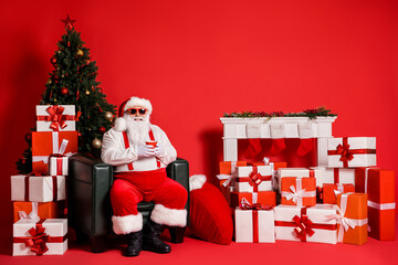 Sticker - Portrait of his he nice attractive funky fat overweight cheerful Santa sitting in armchair drinking beverage in decorated room isolated bright vivid shine vibrant red color background