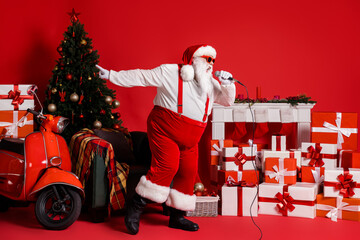 Sticker - Full length photo of crazy santa claus sing pop song in mic isolated on red shine color background with x-mas fireplace chair gift box