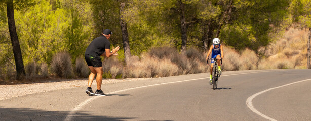 Coach and father cheering up his student and son in a cycling race