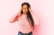 © Asier - Young african american woman isolated on a pink background touching temples and having headache.