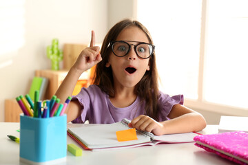 Sticker - Emotional little girl doing homework at table indoors