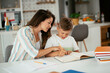 © JustLife - Mother helping her son with homework at home. Little boy learning at home.