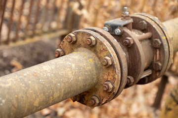 Fragments of old large gas pipe. Rusty brown curved metal iron pipe.