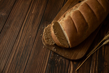 Homemade sliced rye bread on wooden cutting board. Top view