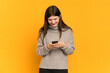 © luismolinero - Young Ukrainian girl isolated on yellow background sending a message with the mobile