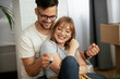 © JustLife - Husband and wife are moving into the apartment. Happy couple is unpacking their belongings..