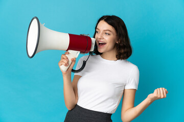 Teenager Ukrainian girl isolated on white background shouting through a megaphone to announce something in lateral position