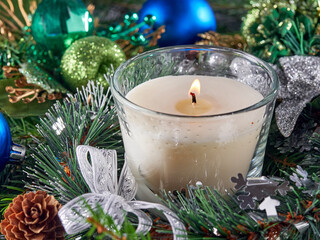 Background of the New year.Candles burn on glass candlesticks, against the background of pine branches and Christmas decorations.