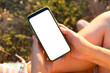 © Shi  - Mockup image blank white screen sitting in the park. Remote control concept. Online training for students. Online shopping. Woman hand holding, using mobile
