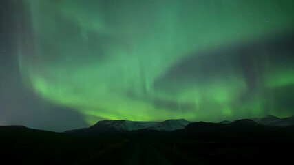 Wall Mural - aurora borealis swirling over mountain road in iceland
