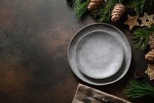 Christmas Rustic Home Table Setting With Empty Gray Plate And Xmas Wooden Decor On Brown Table. Top View, Flat Lay With Copy Space.