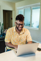 Wall Mural - smiling man working from home on laptop computer