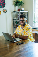 Wall Mural - portrait of smiling man working from home at dining room table