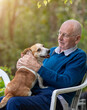 © Budimir Jevtic - Senior man cuddling dog in garden