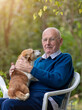 © Budimir Jevtic - Senior man cuddling dog in garden