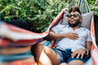 Black man napping in hammock in back yard