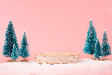 Mock Up With Wooden Podium From A Circle Of Wood On Trendy Pastel Pink Background With Christmas Decoration Tree. Place For Christmas Product Presentation