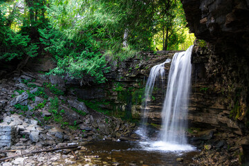 A waterfall flows freely into the river below, at Hilton Falls Conservation Area in Ontario.