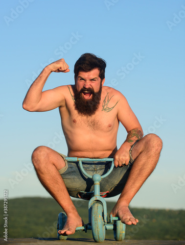 Fotografía Guy riding childs tricycle