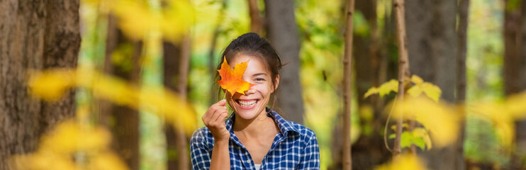 happy asian woman holding red maple leaf to her eye cute portrait outdoor nature banner. panoramic a