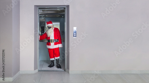 Fotografía Man disguised as Santa Claus with a mask, inside an elevator in a building on Ch