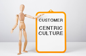 Poster - wooden man shows with a hand to white board with text customer centric culture