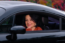Woman Sitting In Black Sports Car In Autumn Forest