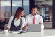 Couple of busy colleagues working together in modern office