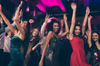© deagreez - Photo portrait of wild crowd dancing together with hands in air at nightclub wearing beautiful formal dresses