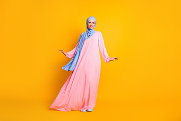 Wall Mural - Full length body size view of nice lovely cheery feminine muslimah wearing hijab dress posing isolated shine yellow color background