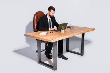 Poster - Full body photo of handsome business guy notebook table chatting colleagues read corporate report wear black blazer shirt pants shoes costume sitting chair isolated grey background