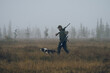 © kingi - Hunter crossing foggy swamp with his dog