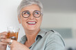 © goodluz - Cheerful 50-year woman drinking hot tea at home