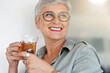 © goodluz - Cheerful 50-year woman drinking hot tea at home