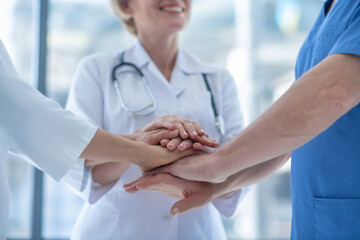 Close-up of medical workers with hands piled up