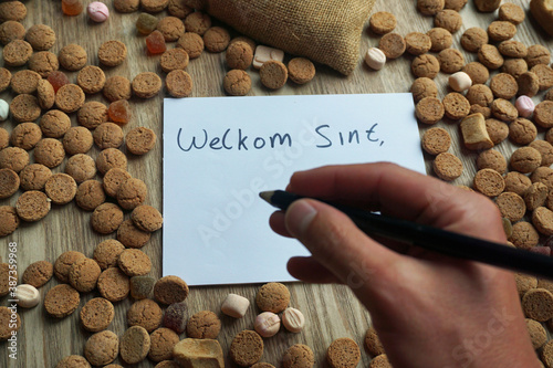 Welcome Santa written in the Dutch language on a paper between ginger nuts.