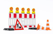 Einzelne Absturzsicherung mit 5 Bakenleuchten gelb-orange, Fußplatten, Schild Baustelle - angelehnt - und Verkehrshütchen Pylone - freigestellt
