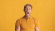 Young excited bearded man looking amazed isolated on yellow background. Wow emotion
