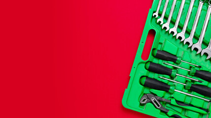 Wall Mural - Green set of construction tools: wrenches, adjustable pliers, screwdrivers and so on on a red background. Banner with place for text for a hardware store. Metal hardware for professional repair or DIY