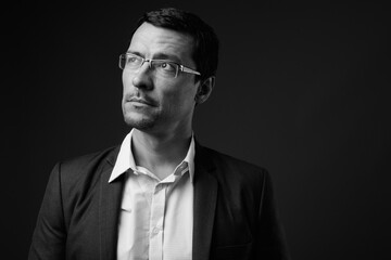 Portrait of handsome businessman in suit against gray background