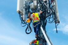 Technician Working On High Telecommunication Tower,worker Wear Personal Protection Equipment For Working High Risk Work,inspect And Maintenance Equipment On High Tower.