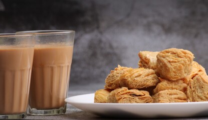 Wall Mural - indian khari or kharee or salty Puff Pastry Snacks, served with indian hot tea.