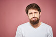 © SHOTPRIME STUDIO - Emotional bearded man in white T-shirt discontent pink background