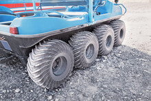 8x8 ATV All-terrain Vehicle Closeup View Of Aggressive Wheels Tread Standing On Sandy Soil