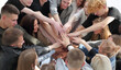 © ASDF - group of diverse people joining their hands in a circle.