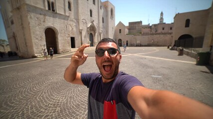 Wall Mural - happy man tourist visiting Apulia region and taking selfie in the main square of the old town of Bari 