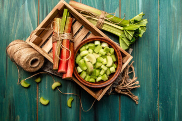 Wall Mural - Rhubarb stalks on a board, Rhubarb in bowl on a wooden background. Rhubarb stalks on a board, Rhubarb in bowl on a wooden background. top view