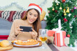 © chinnarach - close up young asian woman holding smartphone to take picture of lunch meal on the table at inside home for christmas festival and  celebration concept