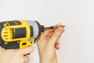 Person drilling in white wall